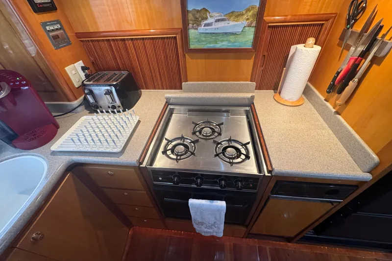 Slide: The Image of Compact kitchen in a 2002 Hampton 550 yacht with stove, toaster, and utensils. - 58