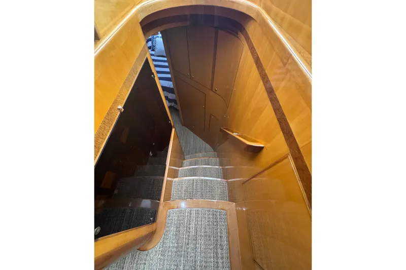 Slide: The Image of Staircase inside 2002 Hampton 550 yacht with wooden finish and carpeted steps. - 61