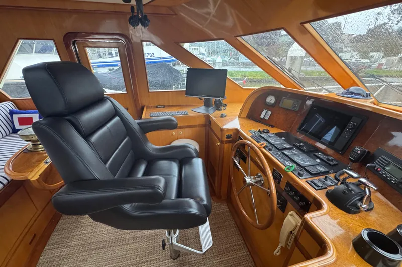 Slide: The Image of Luxurious 2002 Hampton 550 yacht cockpit with leather captain's chair and advanced navigation controls. - 62
