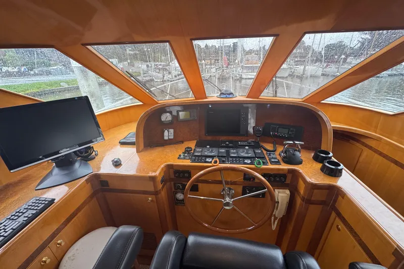 Slide: The Image of Helm of 2002 Hampton 550 yacht with steering wheel, navigation equipment, and panoramic windows. - 63