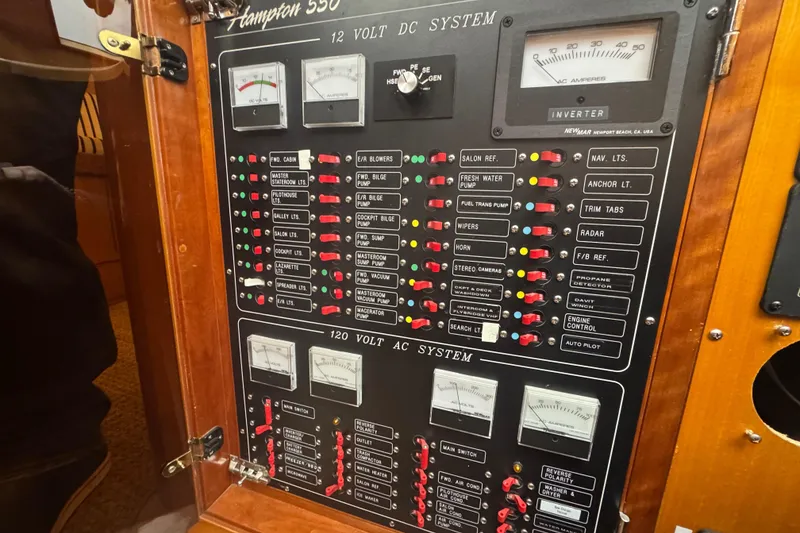 Slide: The Image of Electrical panel of a 2002 Hampton 550 yacht, featuring 12V and 120V systems. - 66