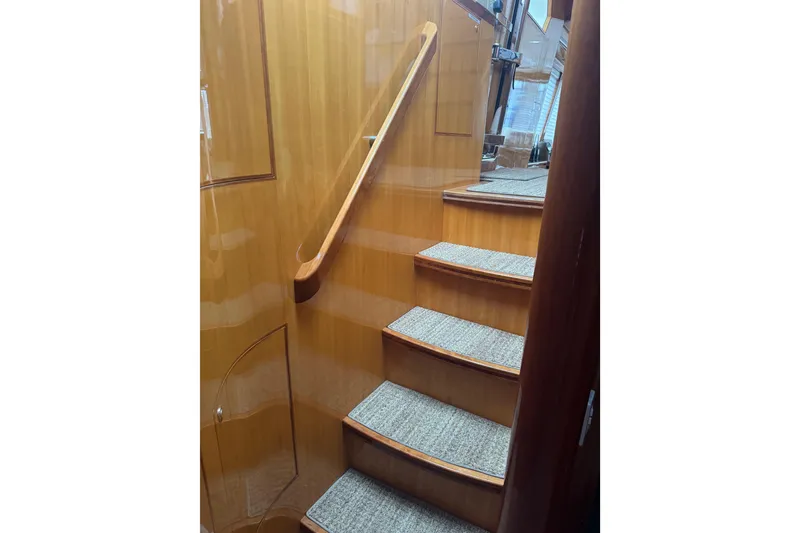 Slide: The Image of Wooden staircase with carpeted steps inside a 2002 Hampton 550 yacht. - 68