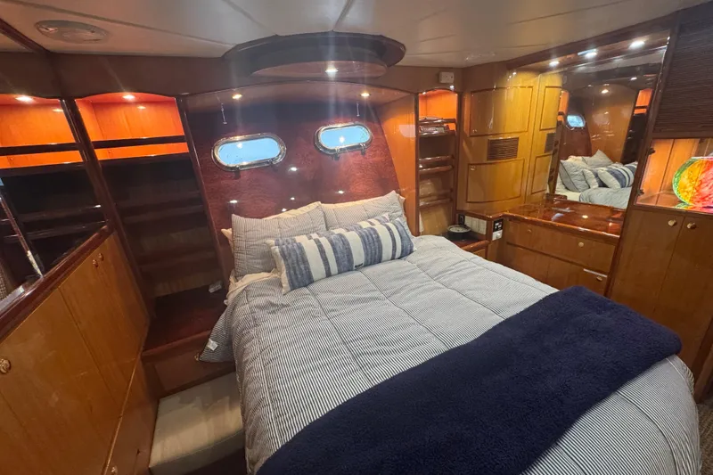 Slide: The Image of Luxurious cabin interior of 2002 Hampton 550 yacht with cozy bedding and wooden furnishings. - 72