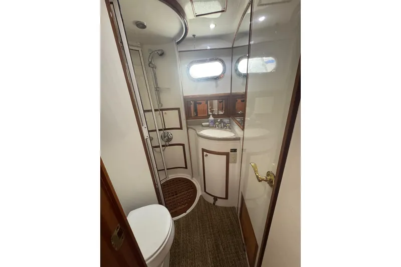 Slide: The Image of Luxurious bathroom in 2002 Hampton 550 yacht with shower, sink, and porthole windows. - 74