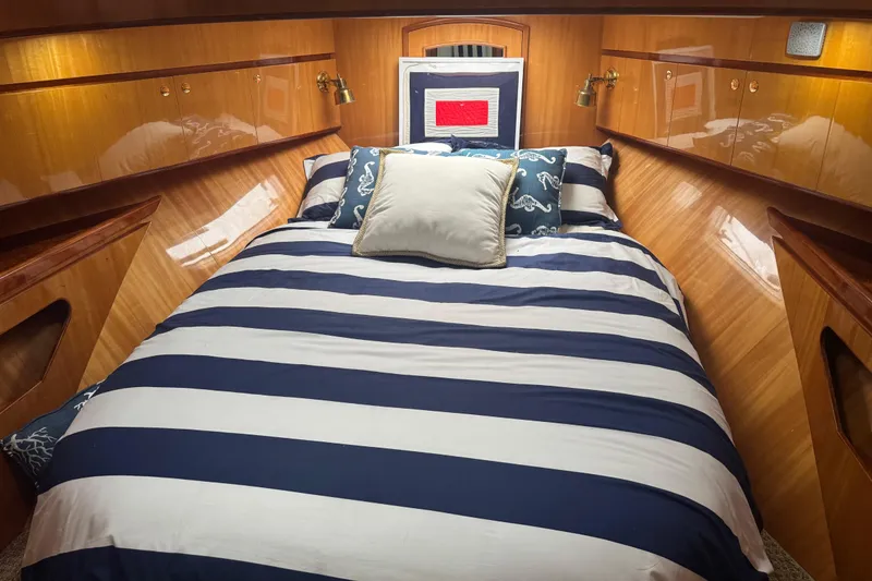 Slide: The Image of Luxurious cabin interior of 2002 Hampton 550 yacht with striped bedding. - 76