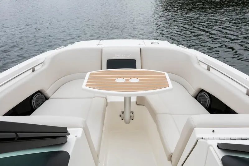 Slide: The Image of 2019 Boston Whaler 230 Vantage boat interior with seating and helm, docked by a canal. - 10