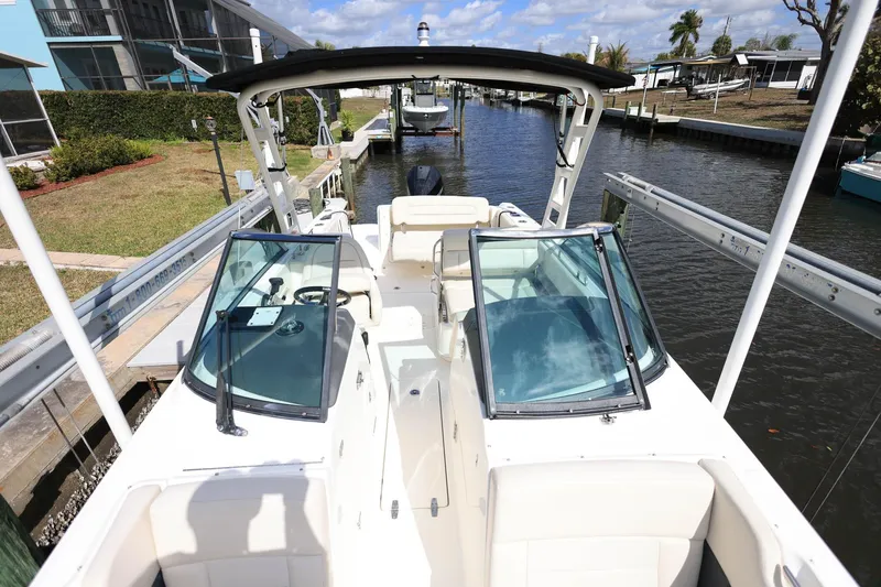 Slide: The Image of 2019 Boston Whaler 230 Vantage boat docked by a canal under a clear blue sky. - 27