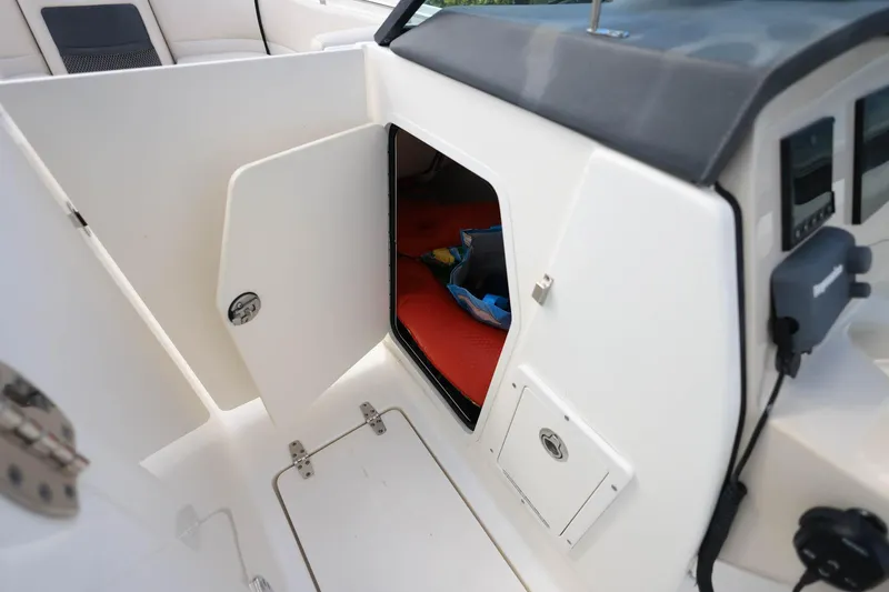 Slide: The Image of 2019 Boston Whaler 230 Vantage boat interior storage compartment with open door. - 29