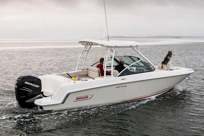Slide: The Image of 2019 Boston Whaler 230 Vantage boat docked in a canal under a clear blue sky. - 3