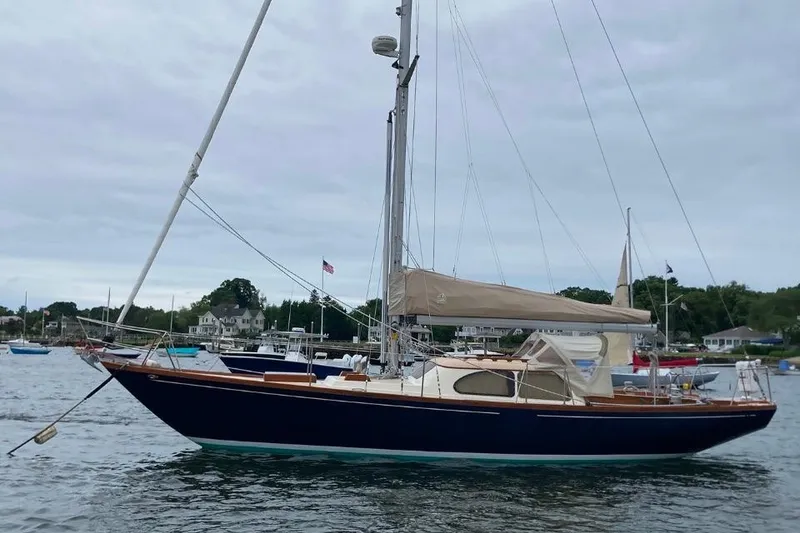Slide: The Image of 1967 Columbia Constellation sailboat anchored in a scenic harbor. - 10