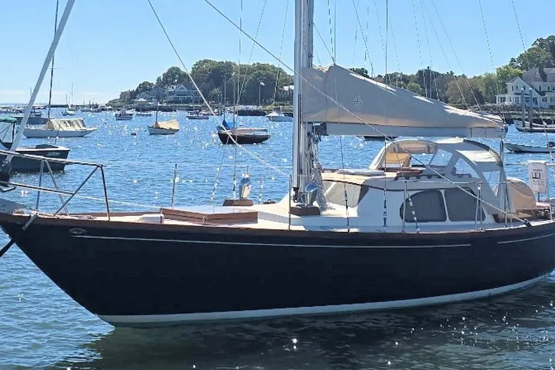 Slide: The Image of 1967 Columbia Constellation sailboat anchored in a scenic harbor. - 12