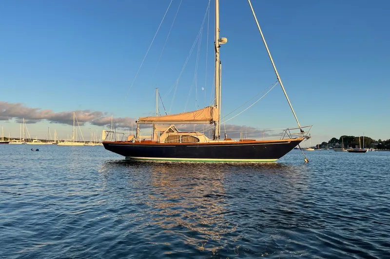 Slide: The Image of 1967 Columbia Constellation sailboat on calm water at sunset. - 13