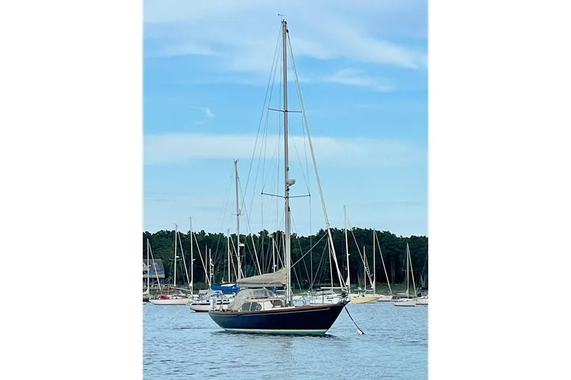 Slide: The Image of 1967 Columbia Constellation sailboat anchored in a serene marina setting. - 15
