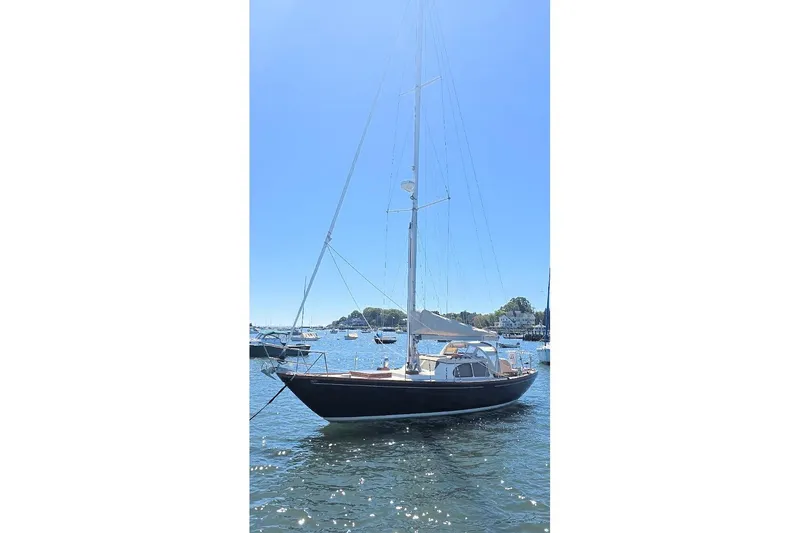 Slide: The Image of 1967 Columbia Constellation sailboat on calm water under clear blue sky. - 18
