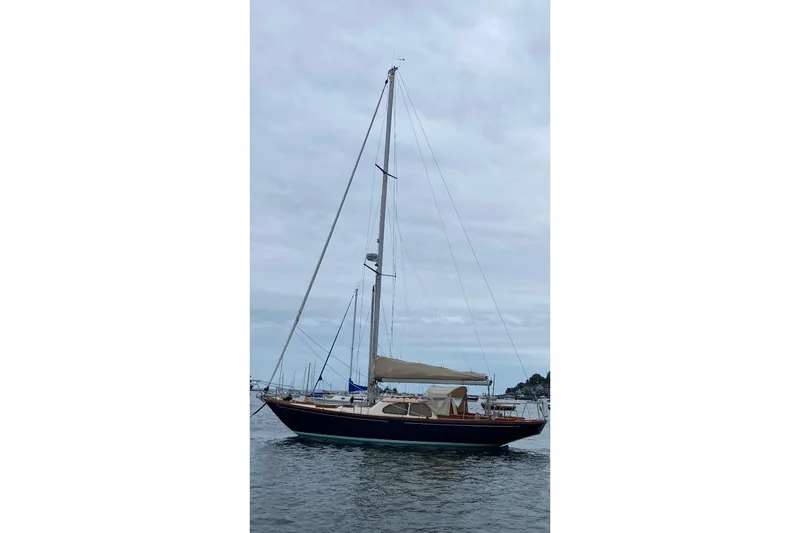 Slide: The Image of 1967 Columbia Constellation sailboat on calm water under cloudy sky. - 19