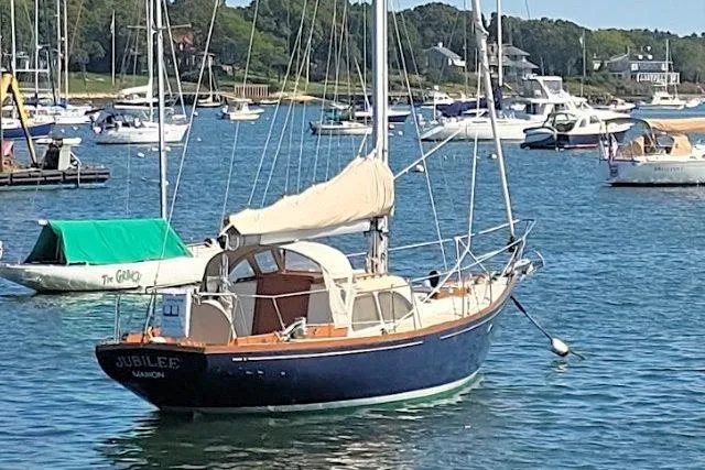 Slide: The Image of 1967 Columbia Constellation sailboat named "Jubilee" anchored in a scenic marina. - 2