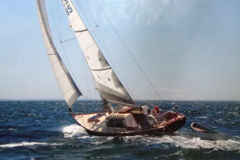 Slide: The Image of 1967 Columbia Constellation sailboat navigating choppy ocean waters under clear skies. - 27