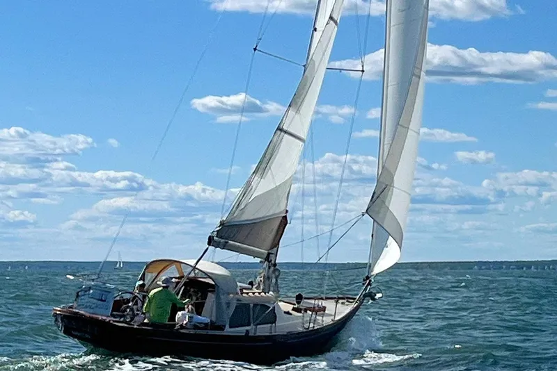 Slide: The Image of 1967 Columbia Constellation sailboat navigating open waters under a clear blue sky. - 28