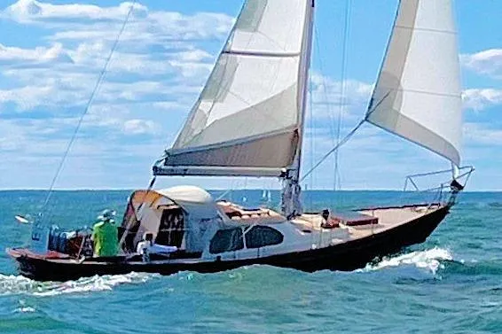 Slide: The Image of 1967 Columbia Constellation sailboat navigating ocean waves under clear blue skies. - 29