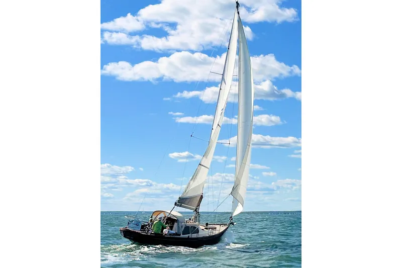 Slide: The Image of 1967 Columbia Constellation sailboat navigating open waters under a clear blue sky. - 35