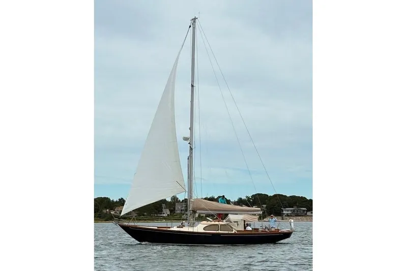 Slide: The Image of 1967 Columbia Constellation sailboat on calm water under a cloudy sky. - 37