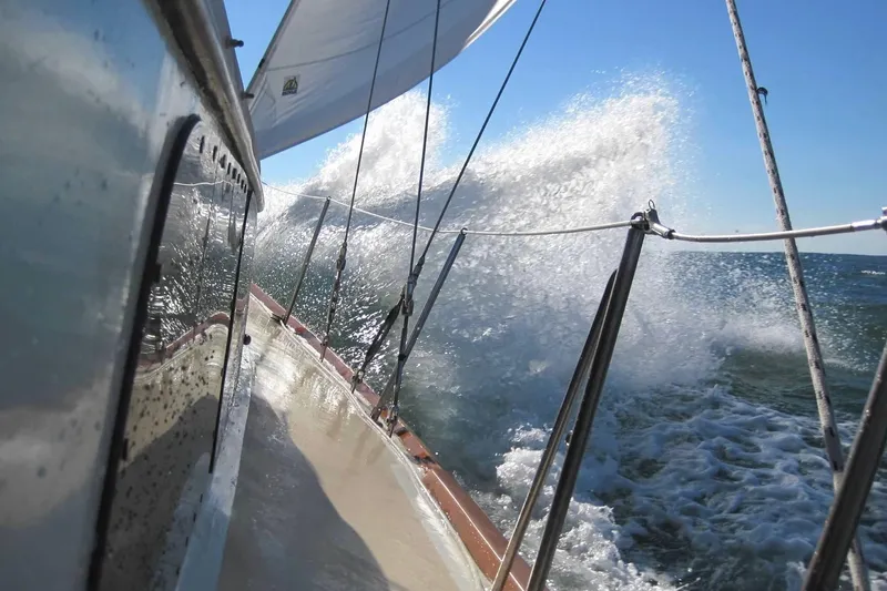 Slide: The Image of 1967 Columbia Constellation sailboat navigating waves under clear blue sky. - 39