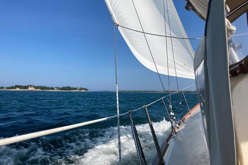 Slide: The Image of Sailing on a 1967 Columbia Constellation yacht with clear blue skies and ocean waves. - 44