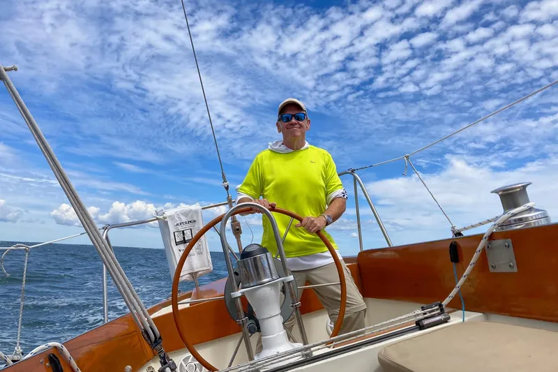Slide: The Image of Man steering 1967 Columbia Constellation sailboat under clear blue sky. - 48