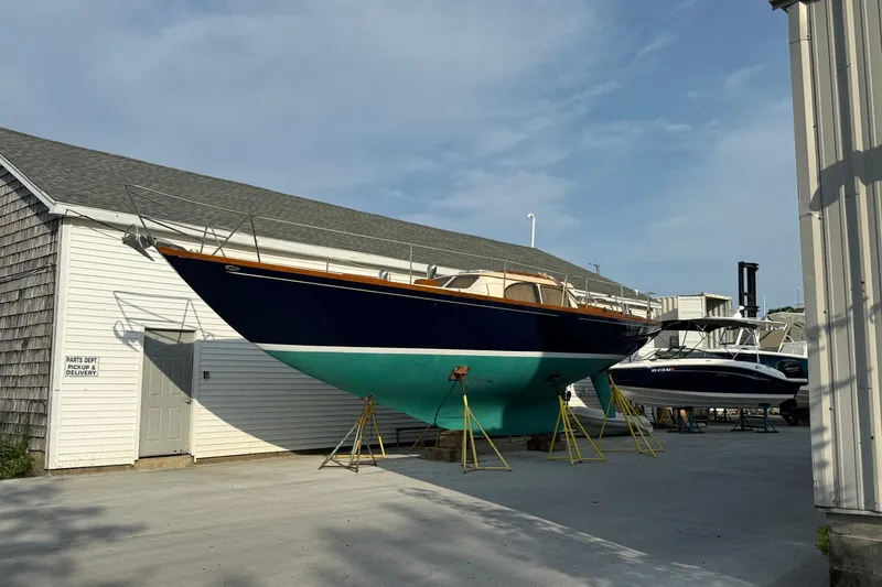 Slide: The Image of 1967 Columbia Constellation sailboat on stands outside a building under a clear sky. - 51