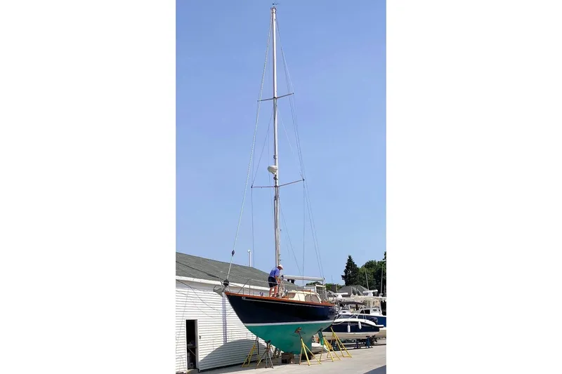 Slide: The Image of 1967 Columbia Constellation sailboat on stands, with a person working on deck. - 52