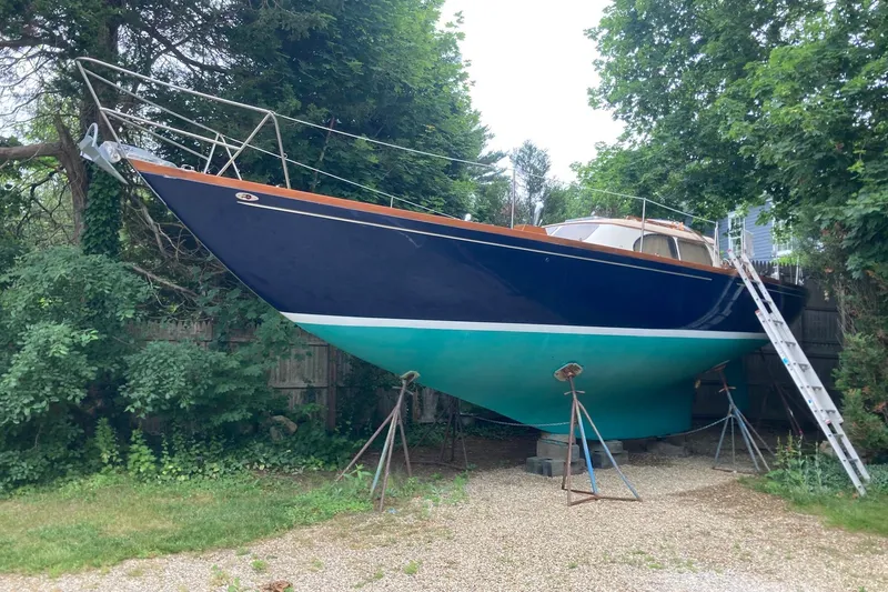 Slide: The Image of 1967 Columbia Constellation sailboat on stands, surrounded by lush greenery. - 56