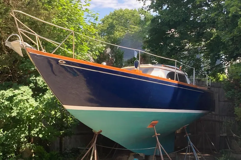 Slide: The Image of 1967 Columbia Constellation sailboat on stands, surrounded by lush greenery. - 57