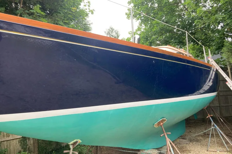 Slide: The Image of 1967 Columbia Constellation sailboat with blue and teal hull, docked on land. - 58