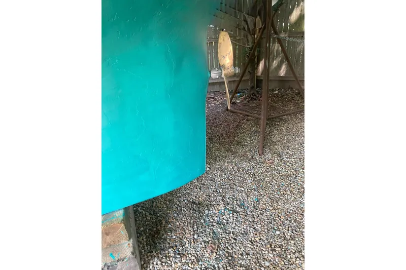 Slide: The Image of 1967 Columbia Constellation boat hull in turquoise, resting on gravel. - 59