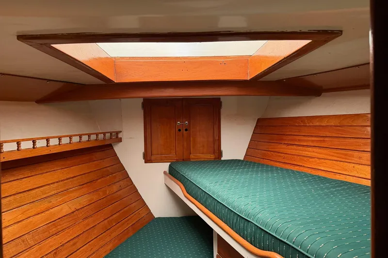 Slide: The Image of 1967 Columbia Constellation boat interior with wooden paneling and green cushioned berth. - 69