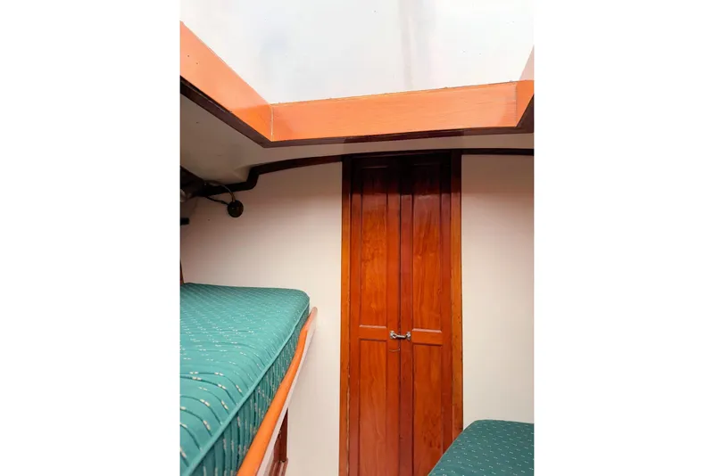 Slide: The Image of Interior of 1967 Columbia Constellation sailboat with wooden door and green cushioned bunks. - 73