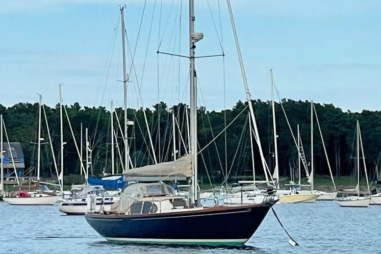 Slide: The Image of 1967 Columbia Constellation sailboat anchored in a serene harbor with other boats. - 8