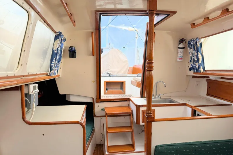 Slide: The Image of 1967 Columbia Constellation yacht interior with wooden finishes and compact kitchen area. - 90