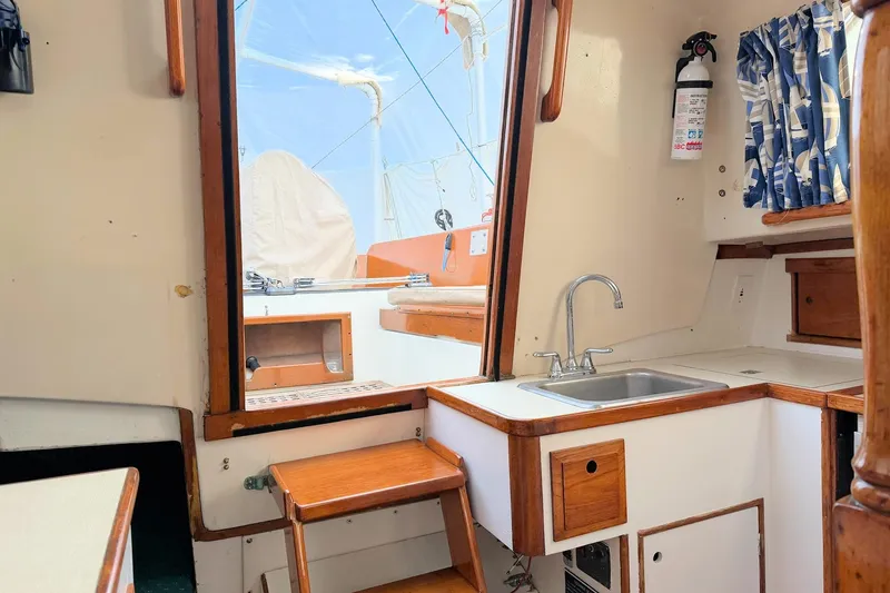Slide: The Image of Interior of a 1967 Columbia Constellation sailboat with wooden accents and compact kitchen area. - 91