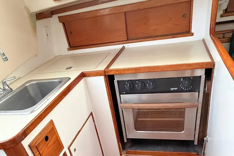 Slide: The Image of 1967 Columbia Constellation yacht kitchen with sink, stove, and wooden cabinetry. - 95