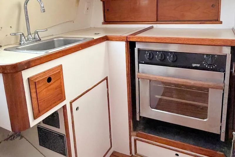 Slide: The Image of 1967 Columbia Constellation boat kitchen with sink and oven, featuring wood accents. - 96