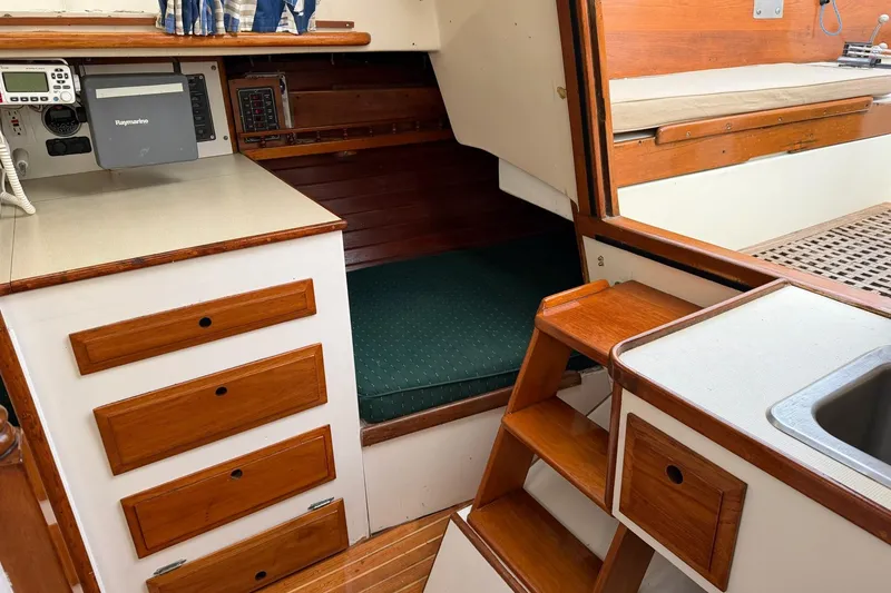 Slide: The Image of 1967 Columbia Constellation yacht interior with wooden cabinetry and green cushioned seating. - 98
