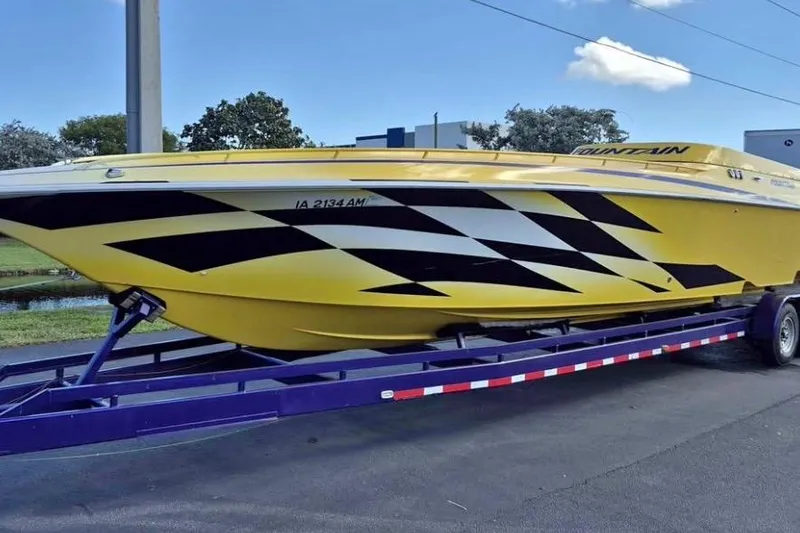 The Image of 1999 Fountain 47 Lightning speedboat in yellow with black graphics on a trailer. - 0
