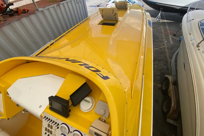 Slide: The Image of Yellow 1999 Fountain 47 Lightning speedboat with cockpit instruments, docked beside other boats. - 13