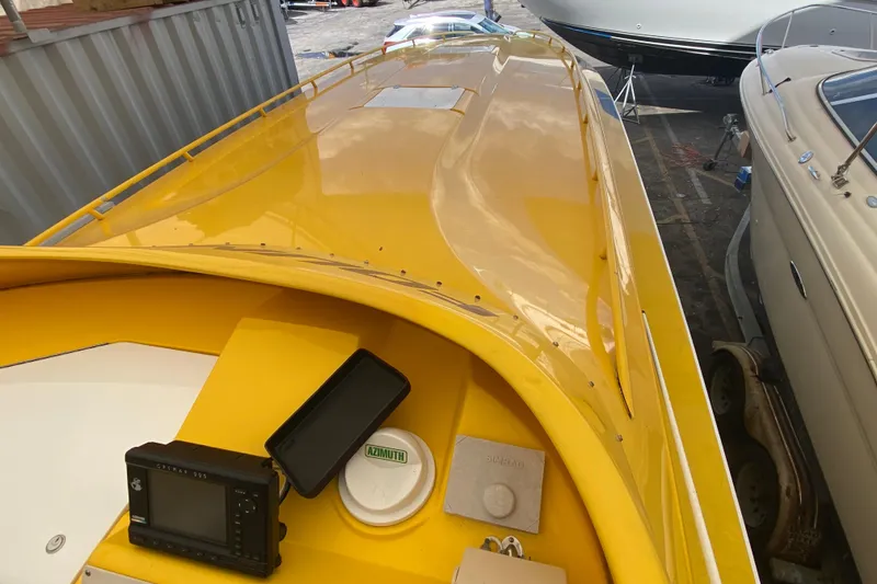 Slide: The Image of Yellow 1999 Fountain 47 Lightning boat with navigation equipment, docked among other boats. - 15