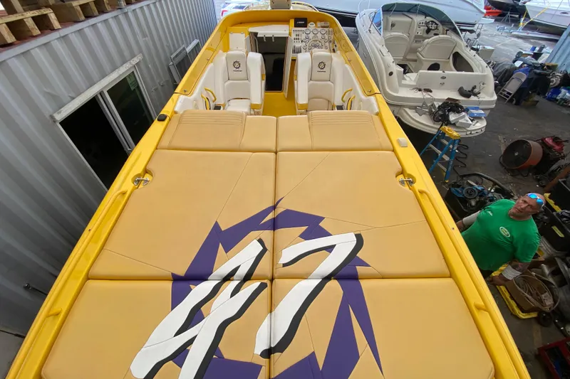 Slide: The Image of Yellow 1999 Fountain 47 Lightning boat with custom seating in a workshop setting. - 16