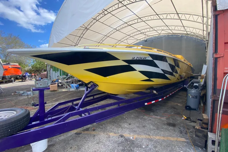 Slide: The Image of 1999 Fountain 47 Lightning boat with yellow and black design on a trailer. - 2