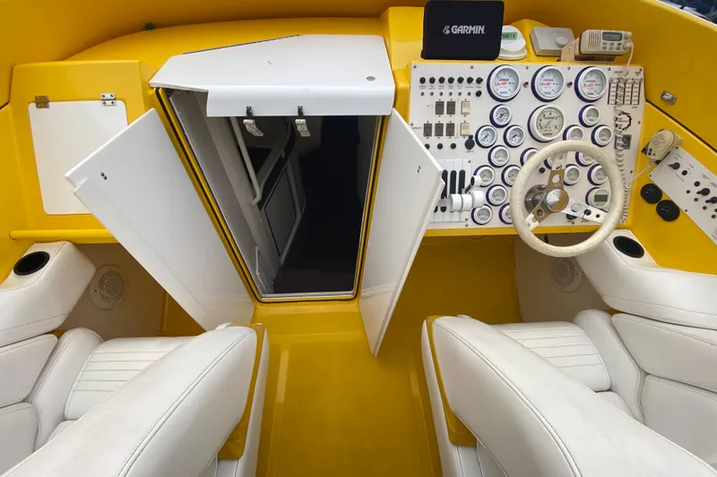 Slide: The Image of 1999 Fountain 47 Lightning boat cockpit with yellow interior and white seats, featuring a Garmin system. - 22
