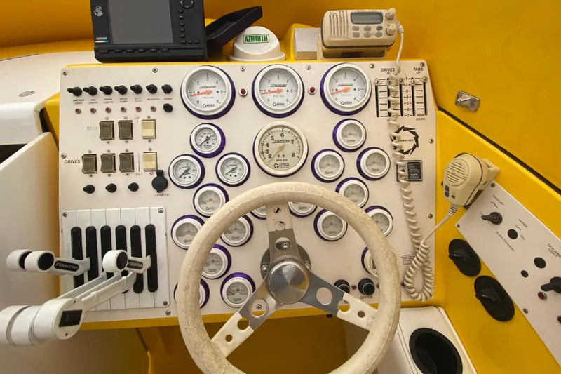 Slide: The Image of 1999 Fountain 47 Lightning boat dashboard with gauges, controls, and steering wheel. - 24