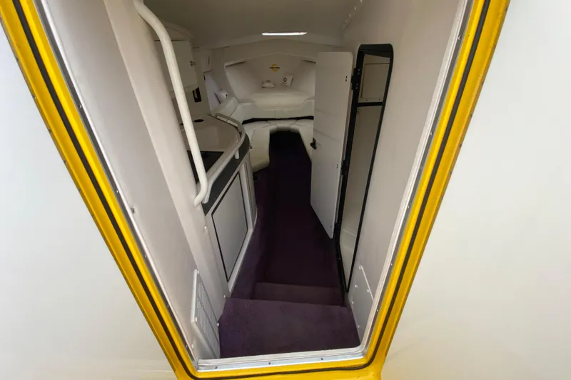Slide: The Image of Interior view of a 1999 Fountain 47 Lightning boat, featuring a compact cabin space. - 26